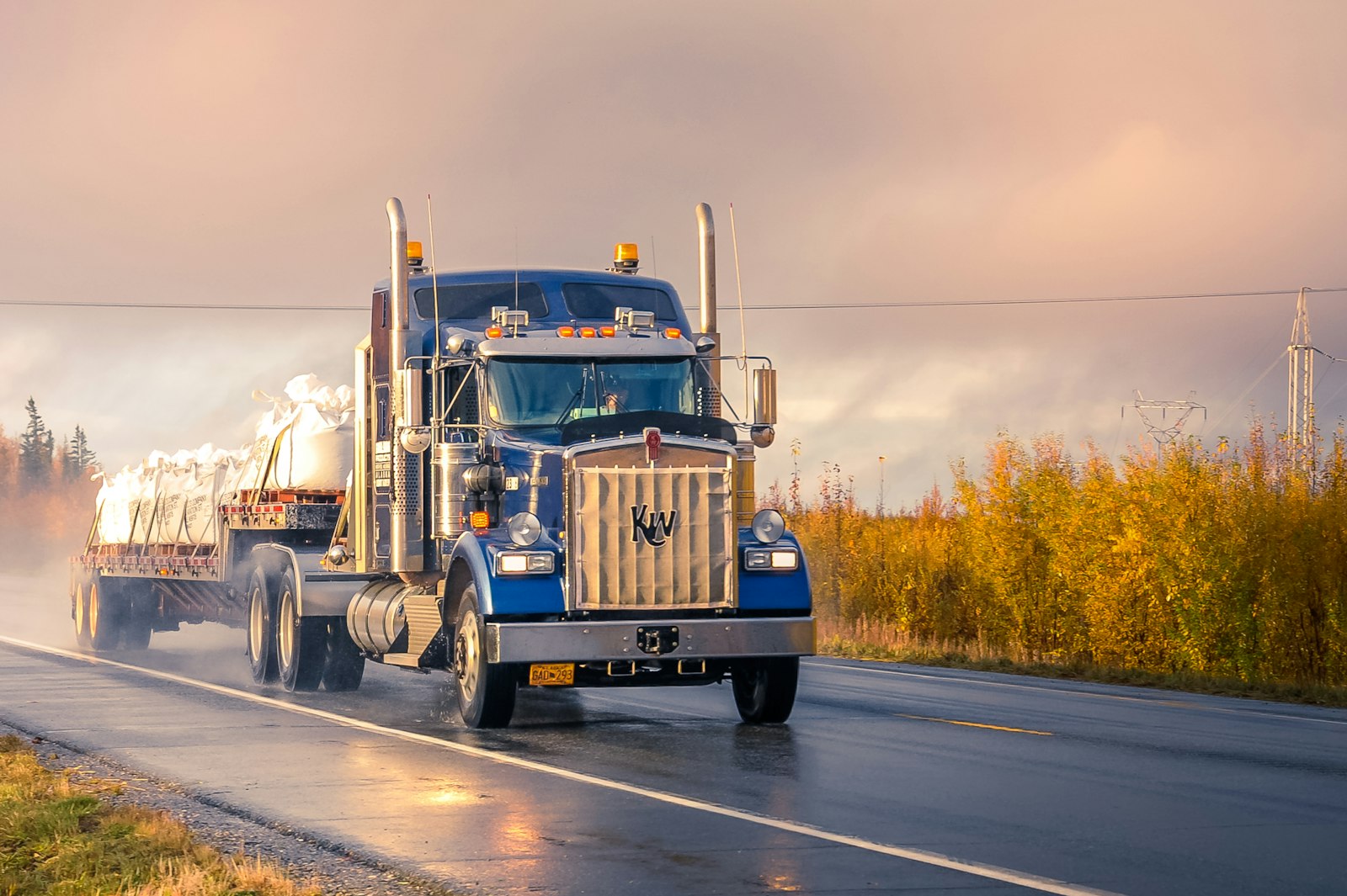 A freight truck on the open road at golden hour
