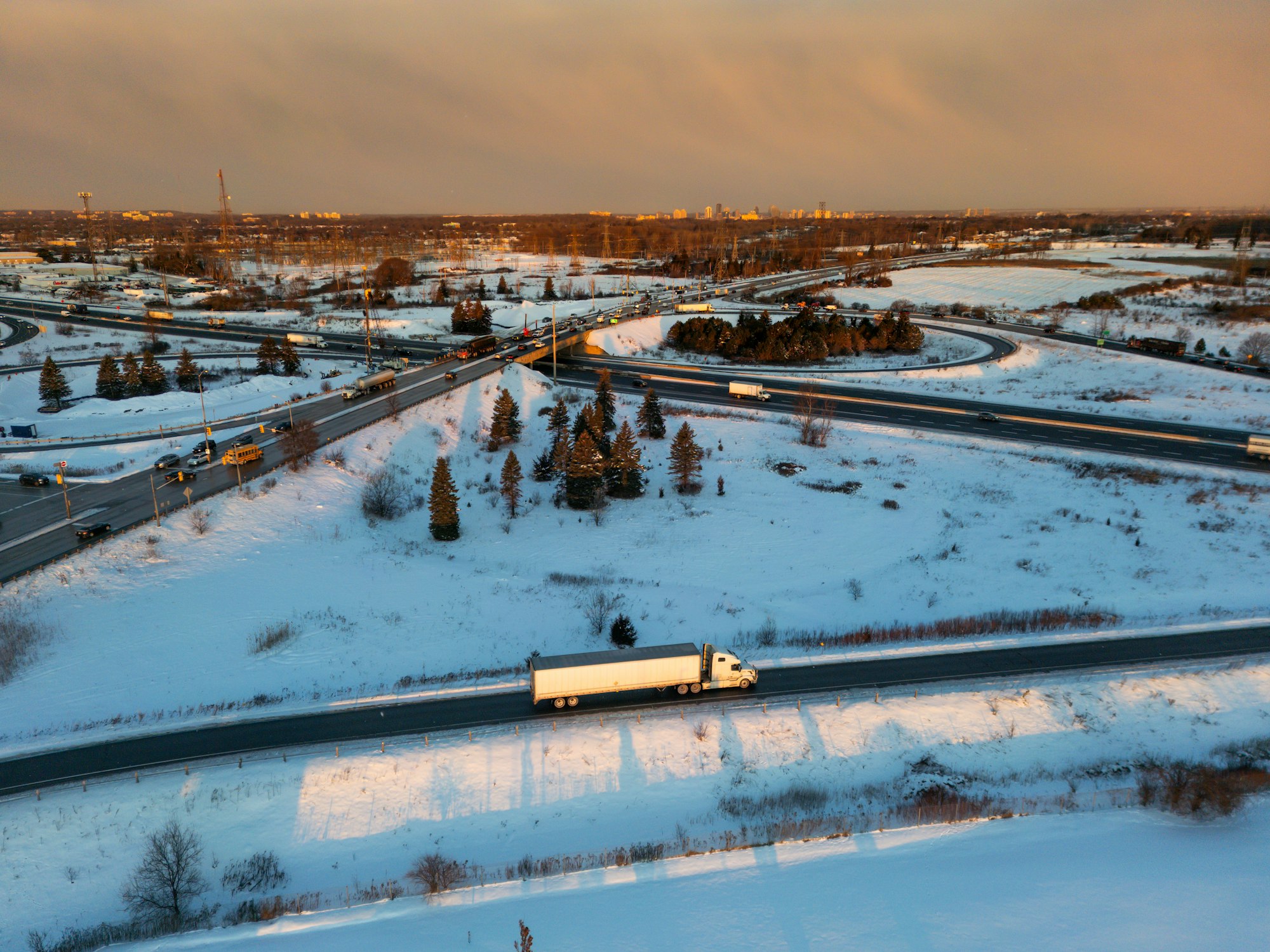 Aerial view of a freight truck traveling an interstate highway at sunset